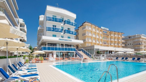 Hotel Außenansicht mit Pool, Liegen und Sonnenschirmen