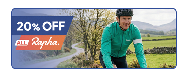 20% OFF ALL RAPHA. A man cycles along a road wearing Rapha Men's Core Rain Jacket III in Green. 