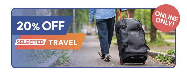ONLINE ONLY: 20% OFF SELECTED TRAVEL. A woman walks along a path, pulling a The North Face Rolling Thunder Luggage 28 in Black. 