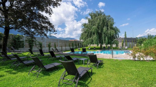 Hotel Garten mit Pool und Liegen und Blick zum See