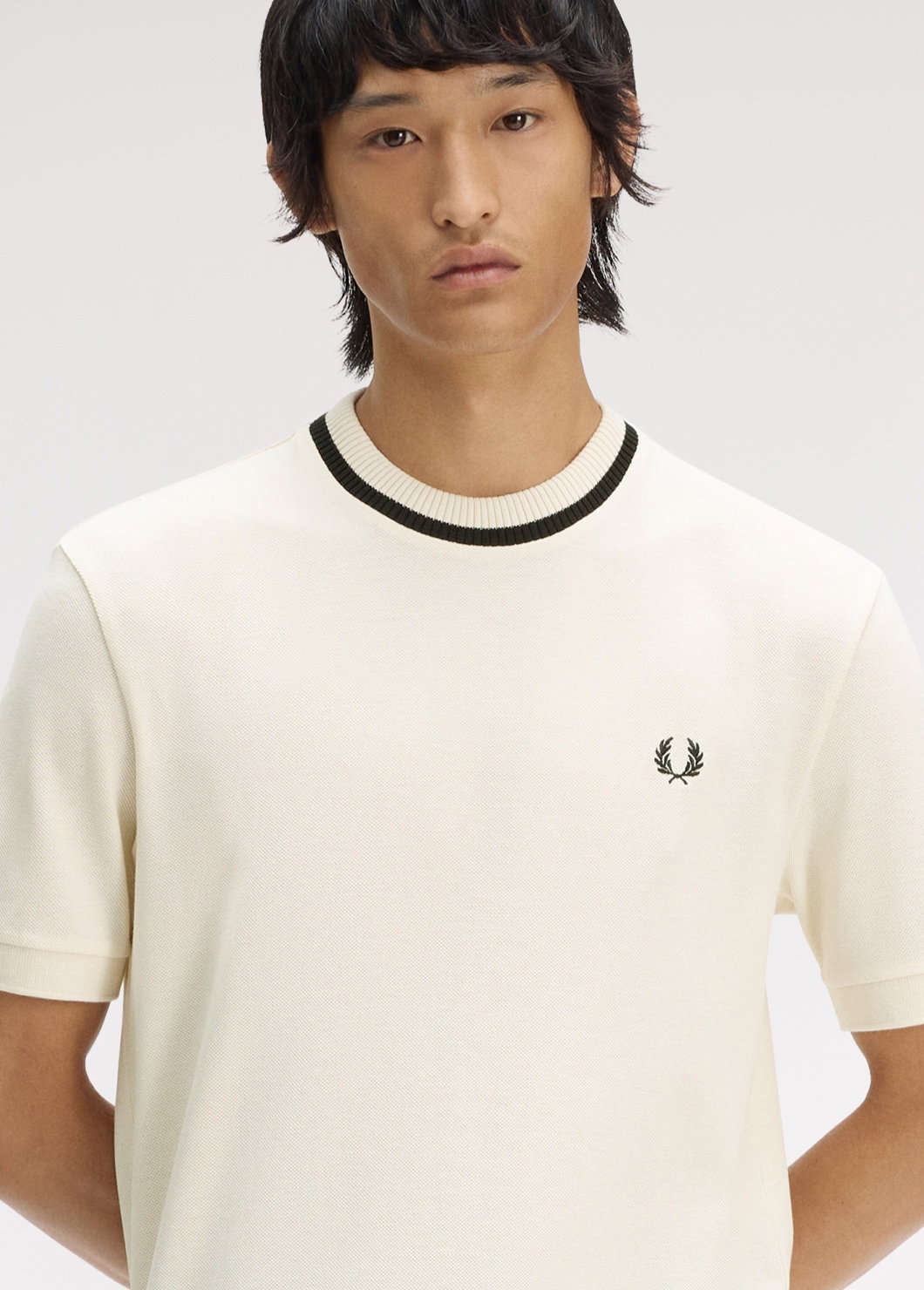 New Releases: male model wears an ecru knitted t-shirt with black rim
