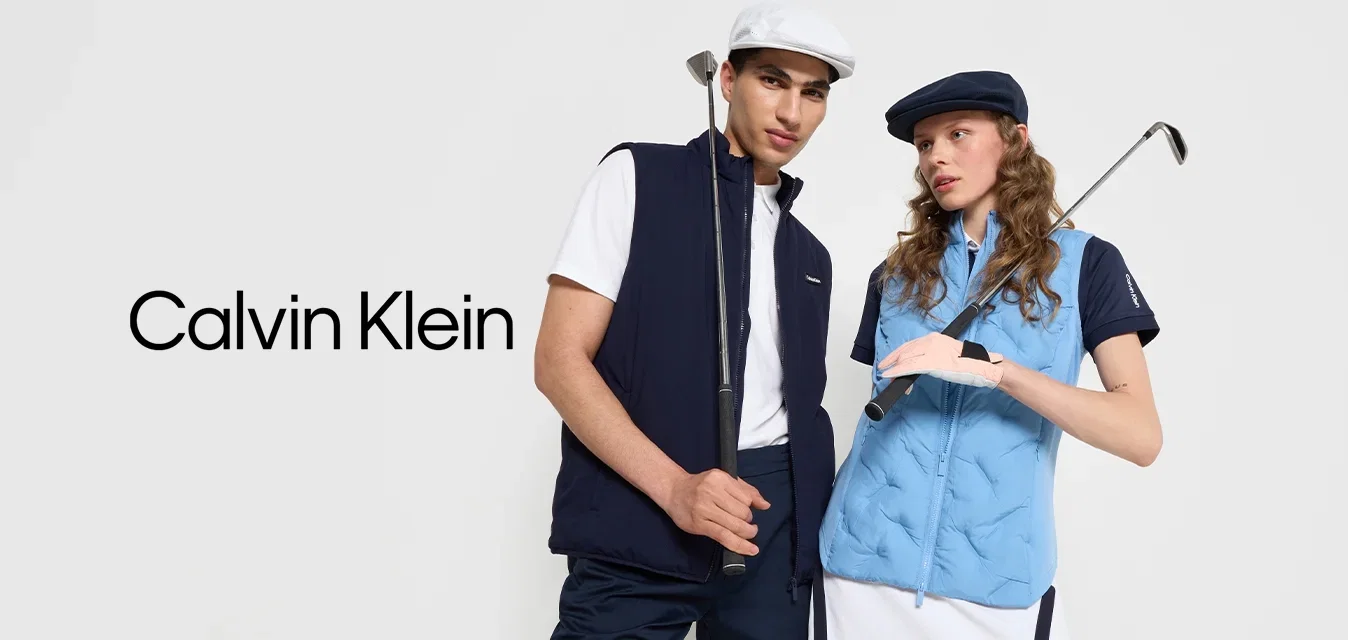 Twee personen in golfkleding: de ene in een marineblauw vest en shorts, de ander in een lichtblauw gewatteerd vest en een witte rok, met golfclubs in hun hand.