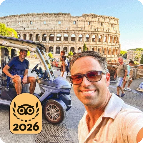 Descripción de la imagen: Dos personas sonriendo frente al Coliseo. Una de ellas está montada en un carrito de golf. En la imagen hay una medalla dorada de Lo mejor de lo mejor de Travellers' Choice de 2026.
