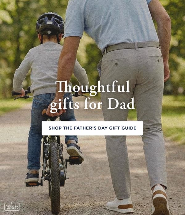 Father pushes son on bike, text overlay says "Thoughtful gifts for Dad, Shop the Father's Day Gift Guide"