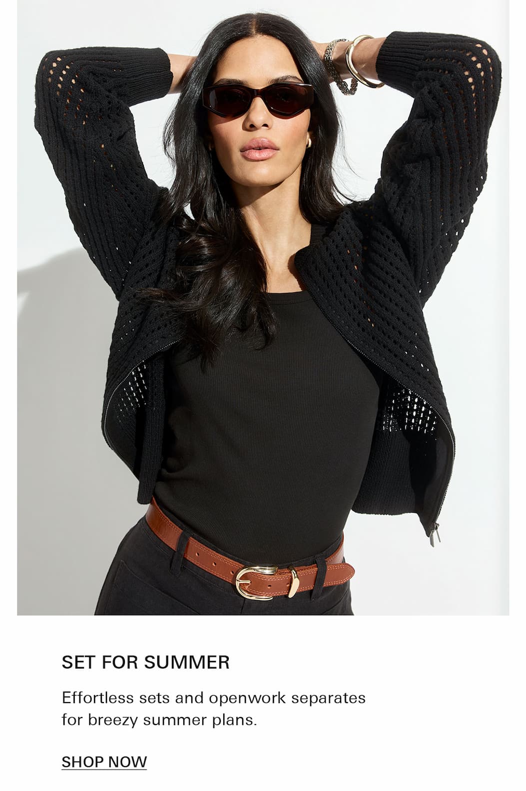 Women wearing laguna openwork bomber in black and sunglasses and belted black pants