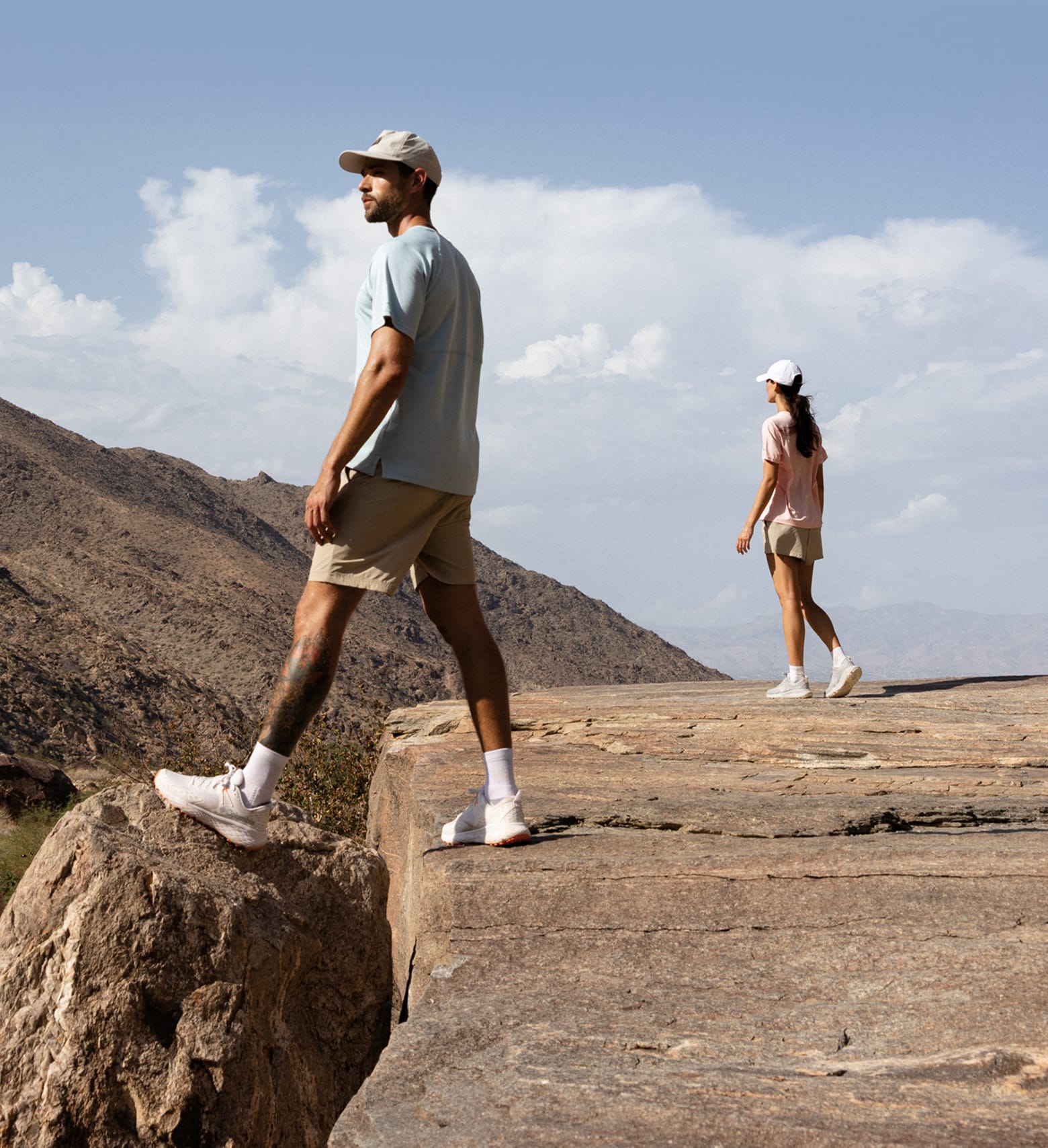 Two hikers on top of a cliffside. 