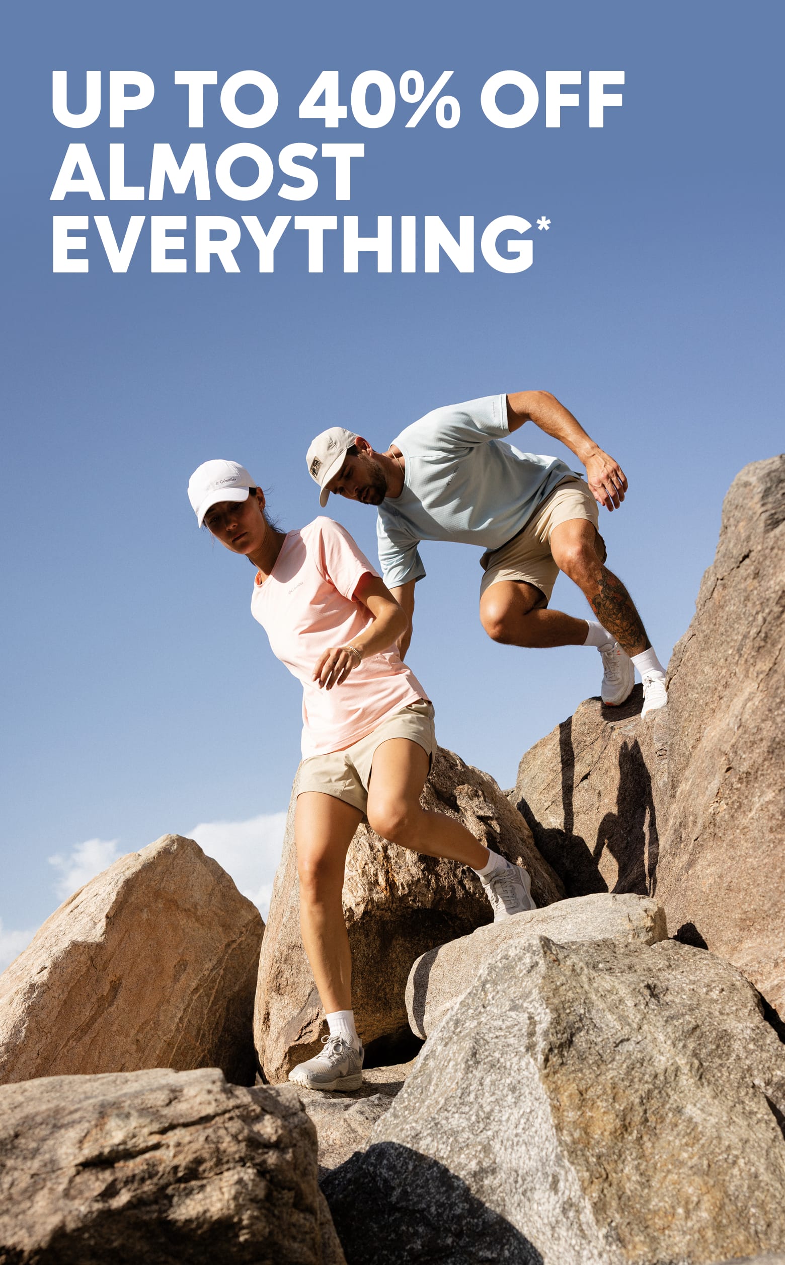 Up to 40% off almost everything*. Two hikers climbing down rocks