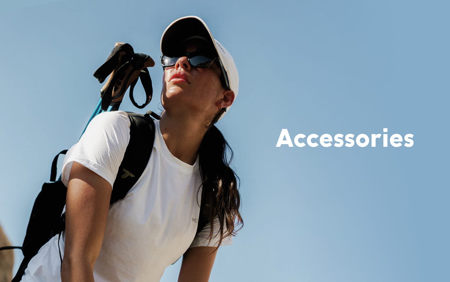 Woman wearing sunglasses, hat, backpack and hiking poles. Accessories. 