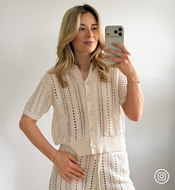 Frauenmodel trägt gestricktes Oberteil in Beige mit Knopfleiste, gestreiftes Muster, kurze Ärmel, Vorderansicht
