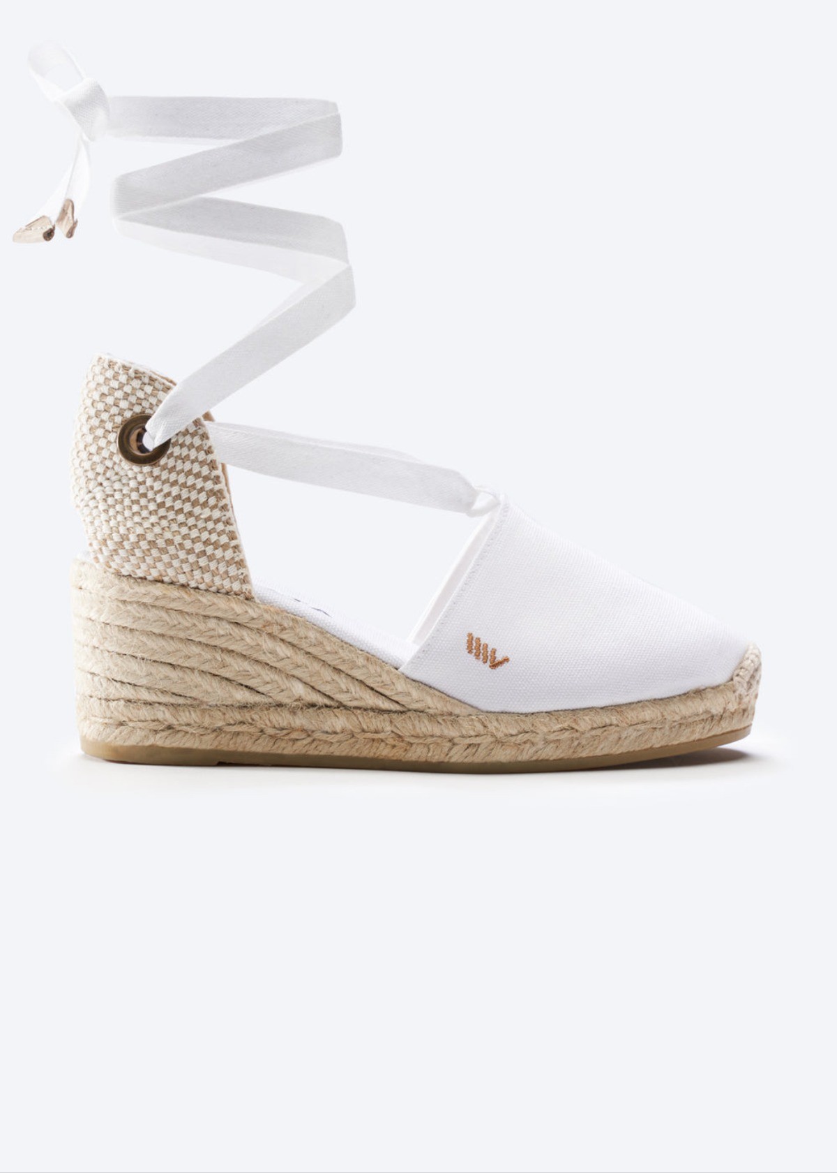 White lace-up espadrille wedge sandals with braided jute platform on a clean background.