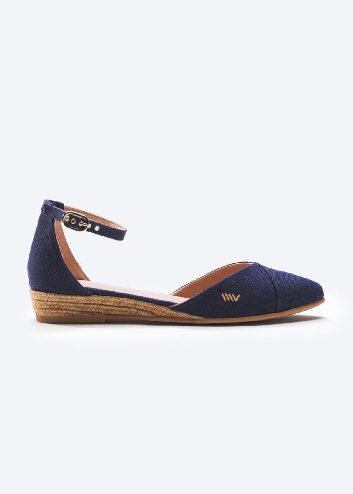 Navy canvas espadrille flats with ankle strap and braided jute sole on a clean background.