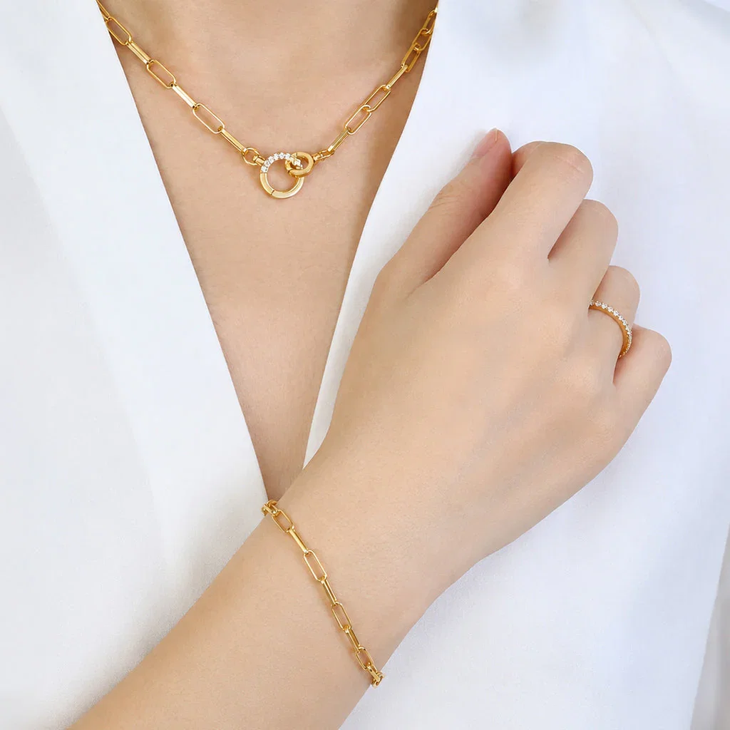 Gold chain necklace and bracelet set with diamond accents displayed on model's neck and wrist
