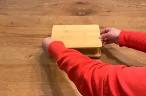She placed 2 Dollar Tree cutting boards on top of each other for surprisingly useful kitchen storage