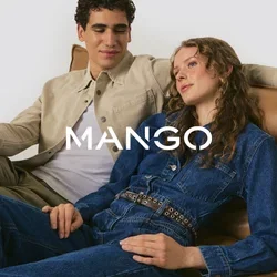 Zwei Personen sitzen auf einem hellbraunen Ledersofa. Die eine trägt eine beigefarbene Jacke über einem weißen Hemd, die andere einen blauen Denim-Overall mit einem Gürtel.