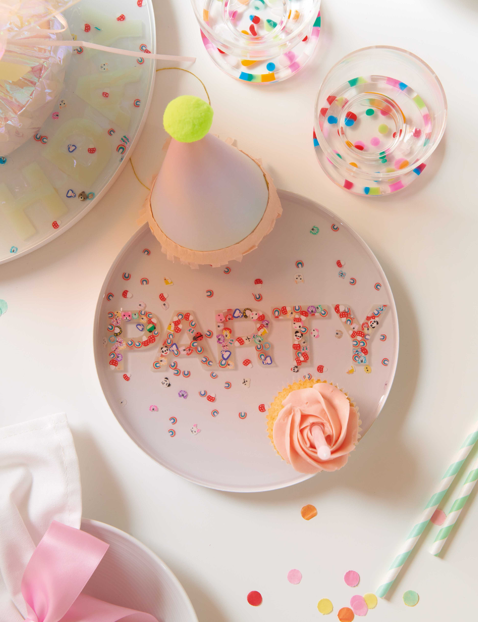 Bunte Untersetzer und Buchstaben aus Resin auf Partytisch