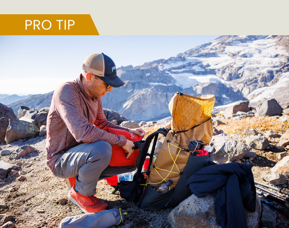 Man adjusting pack on ridge
