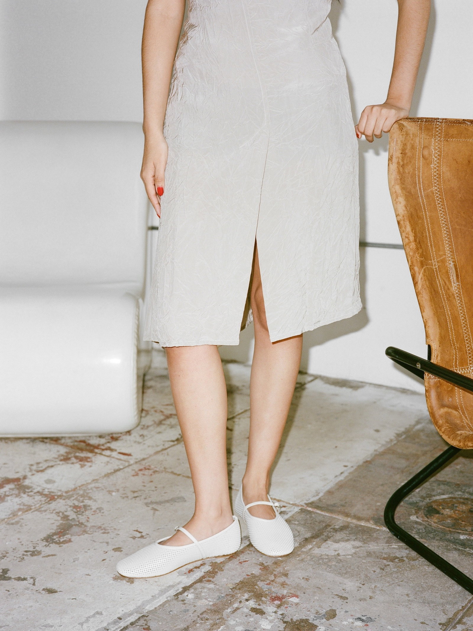 Person standing beside chair wearing white Mary Jane flats