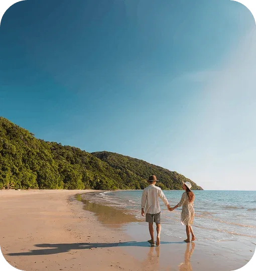View of a couple walking down the beach 