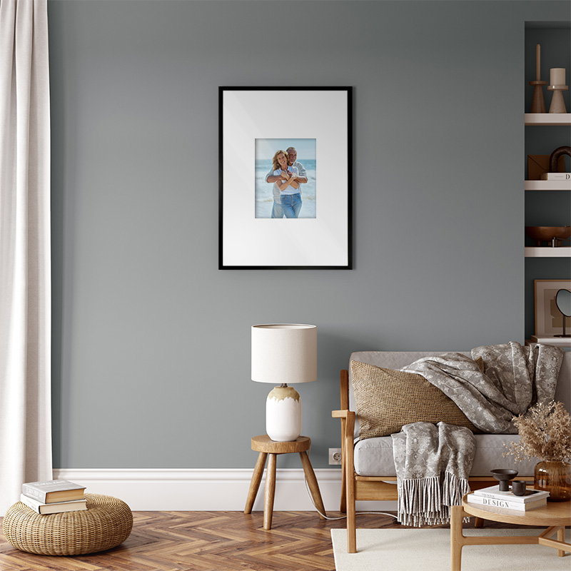 Modern living space with grey accent wall, armchair, floor lamp, and framed artwork.