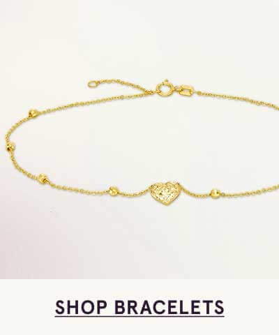 Gold bracelet with spaced out small, ball-like pendants & heart. Click here to shop bracelets