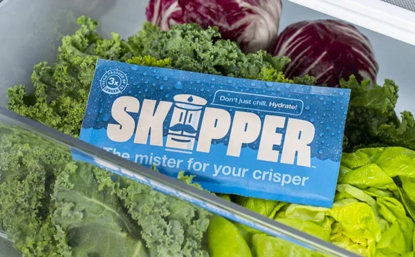 A Skipper sitting in a bed of fresh, crisp vegetables.