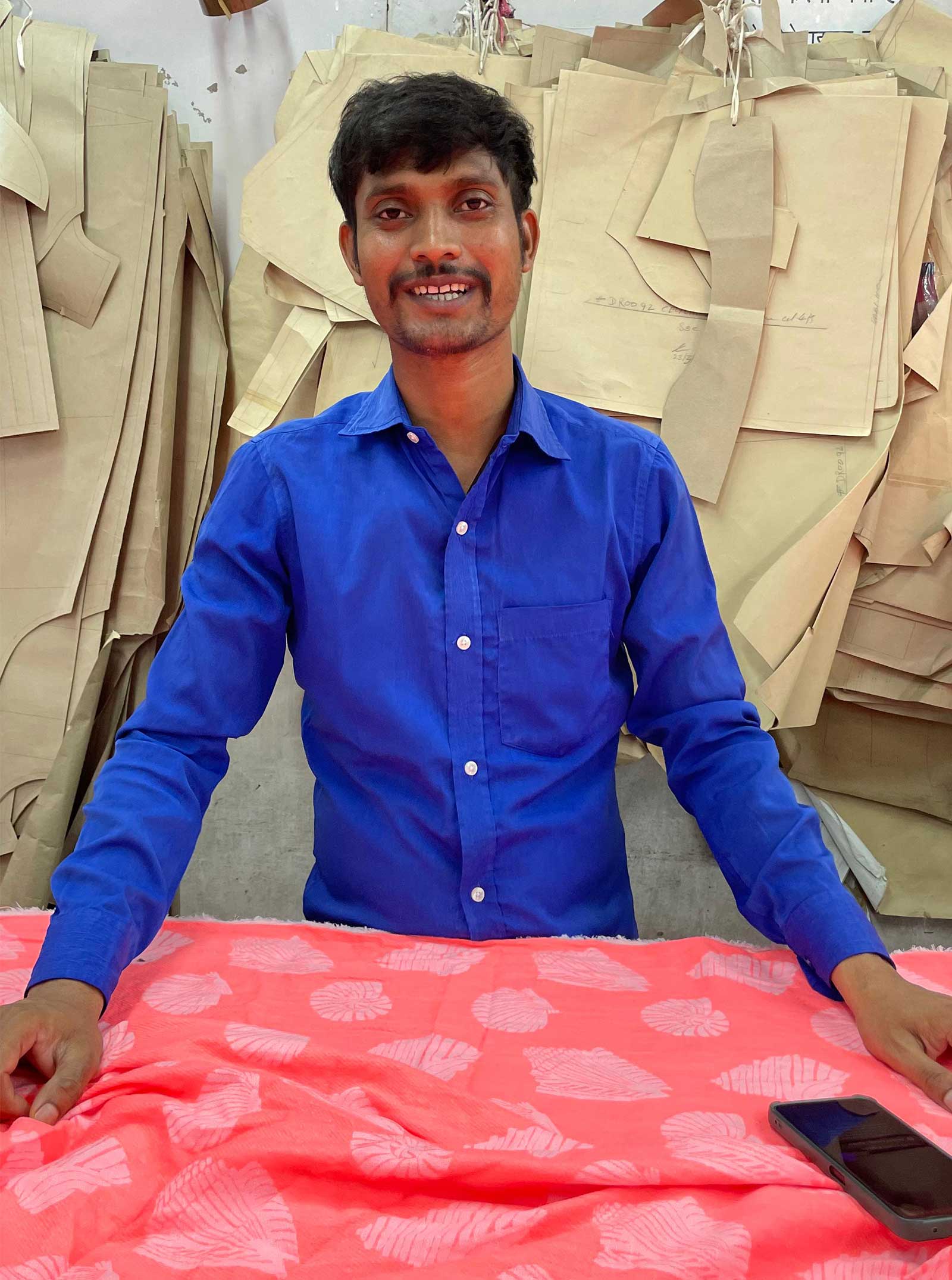 man cutting pink textile