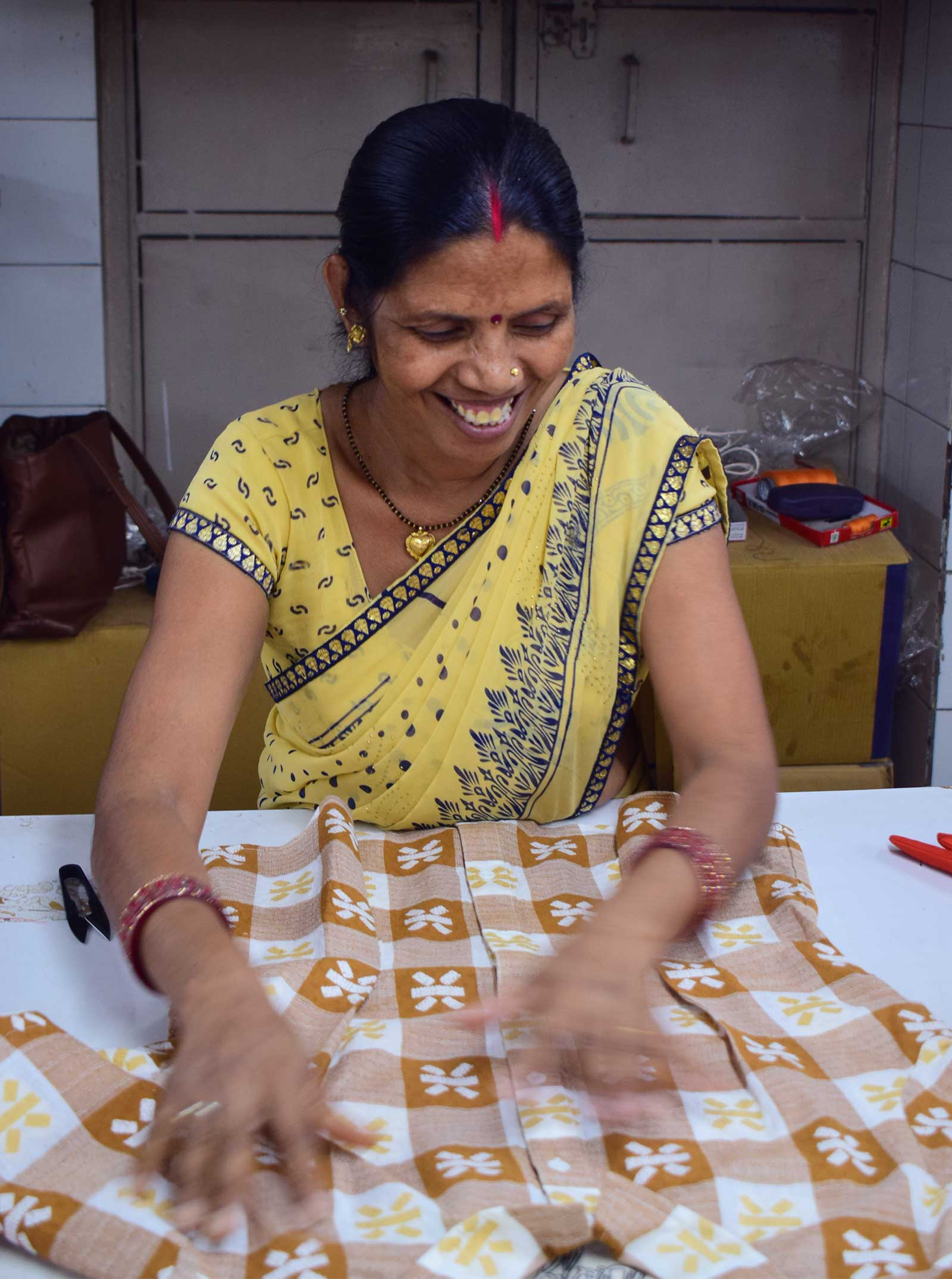 smiling woman checking buttons on garment