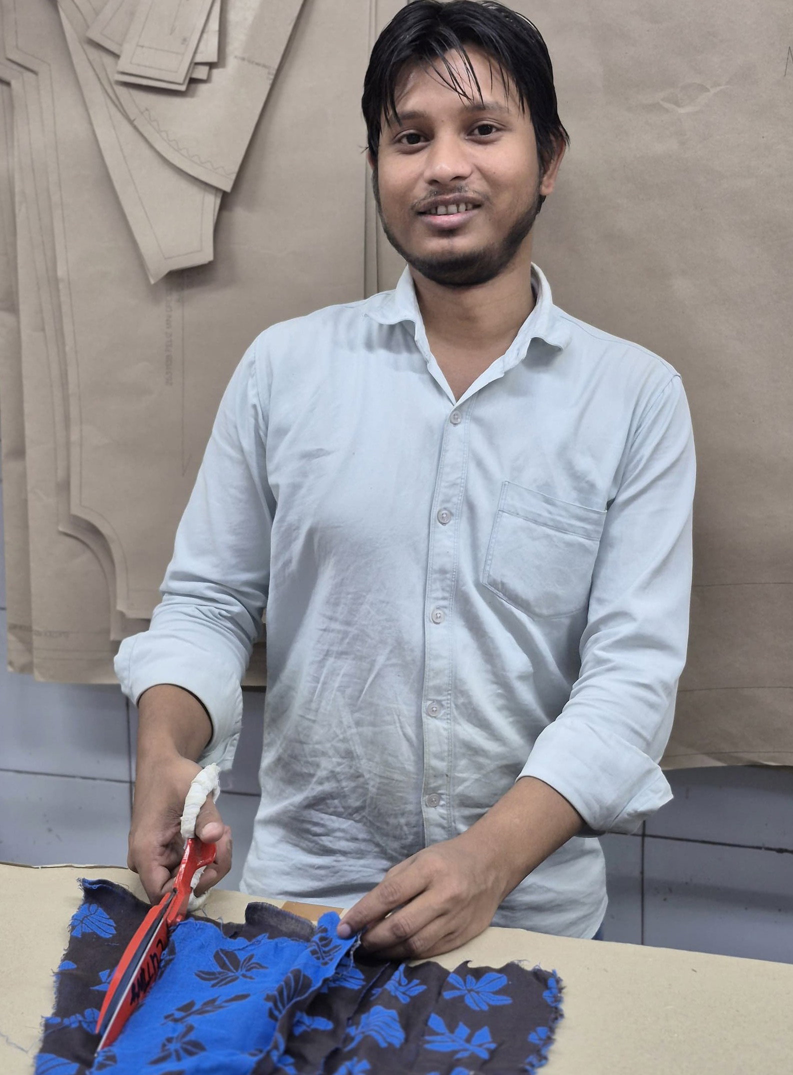 man cutting blue textile