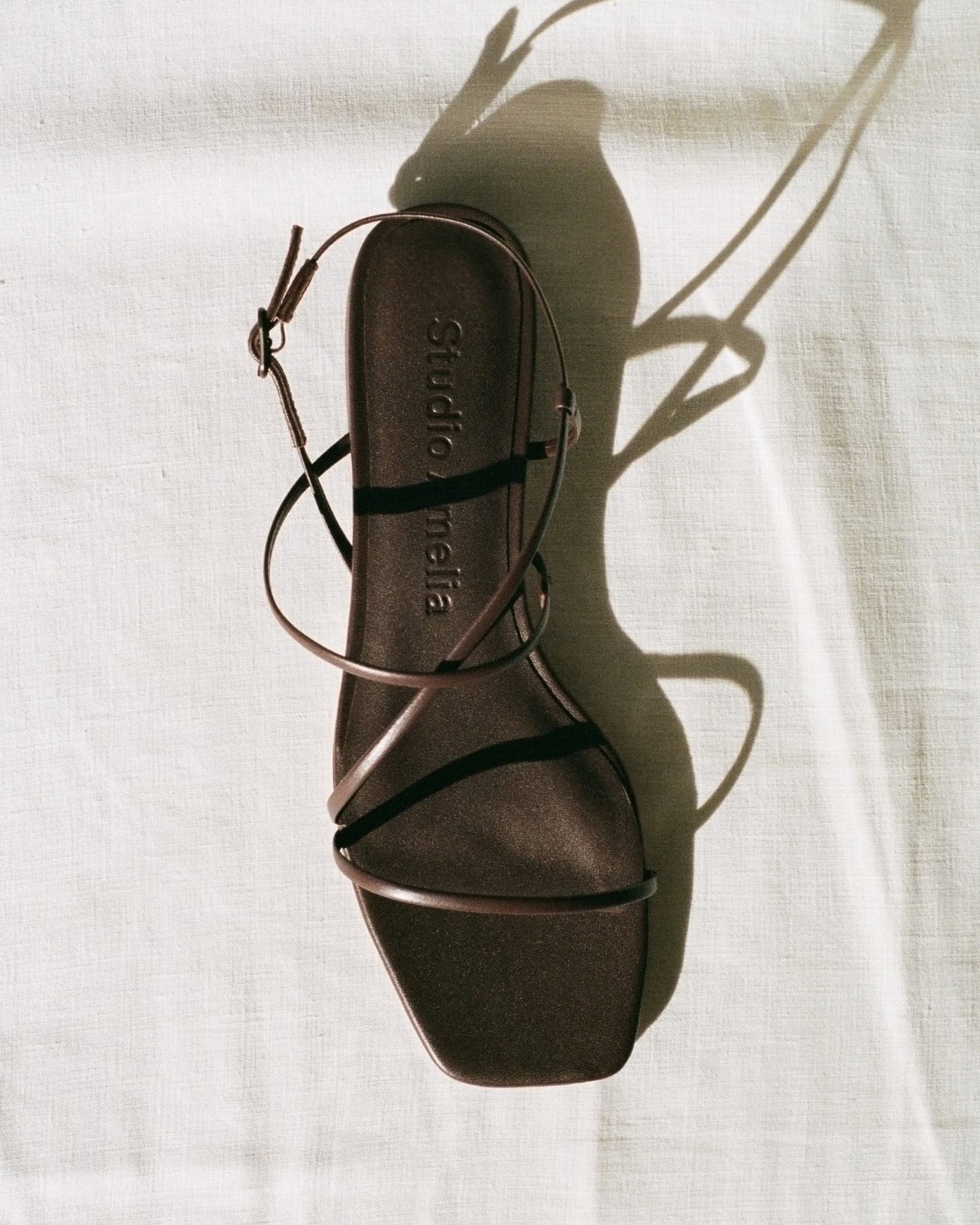 A brown leather sandal with cross straps