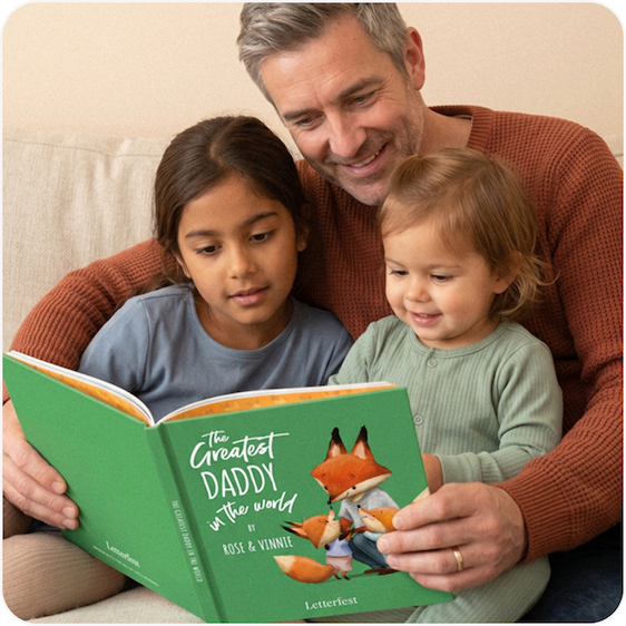A father and two children sitting together reading a personalised Greatest Dad story book