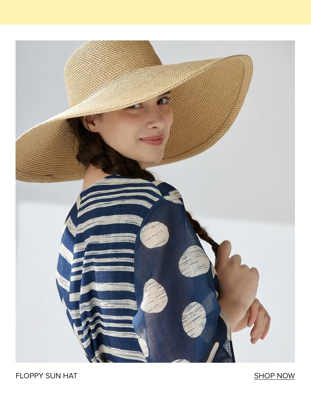 Woman wearing a floppy sun hat and a patterned blouse, smiling at the camera.