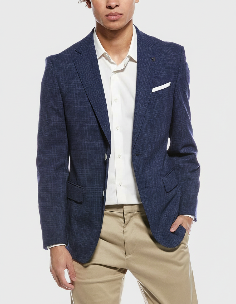 Man in a blue plaid blazer, white shirt, and tan pants with his hand in his pocket.