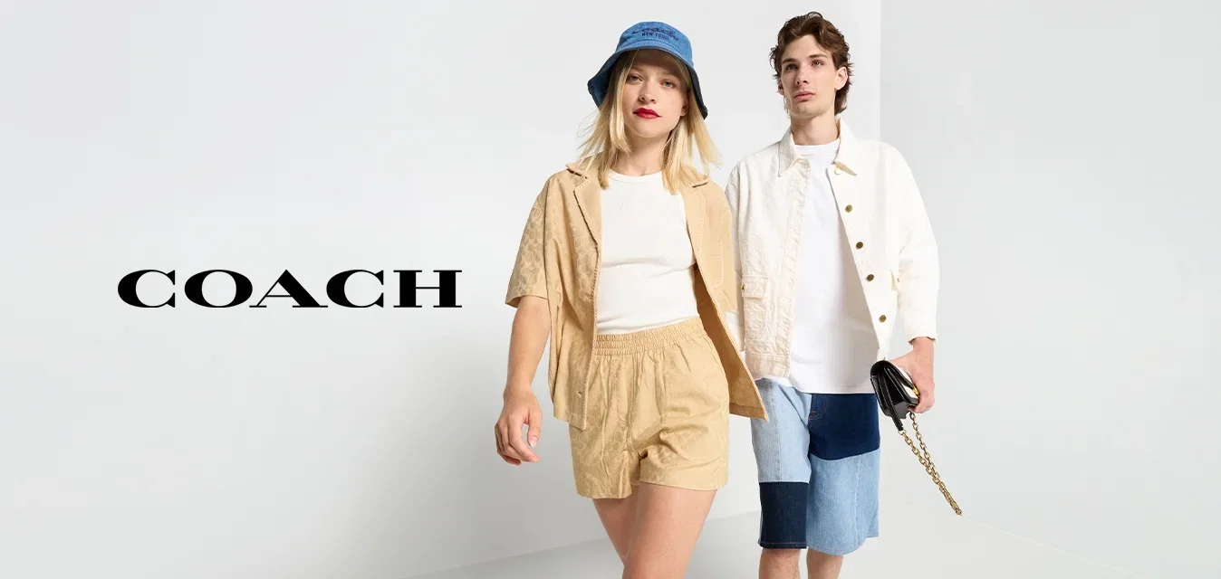 Twee modellen lopen op een witte ondergrond. De ene draagt een beige set met shorts en een bijpassend shirt, de andere in een wit shirt en denim shorts.