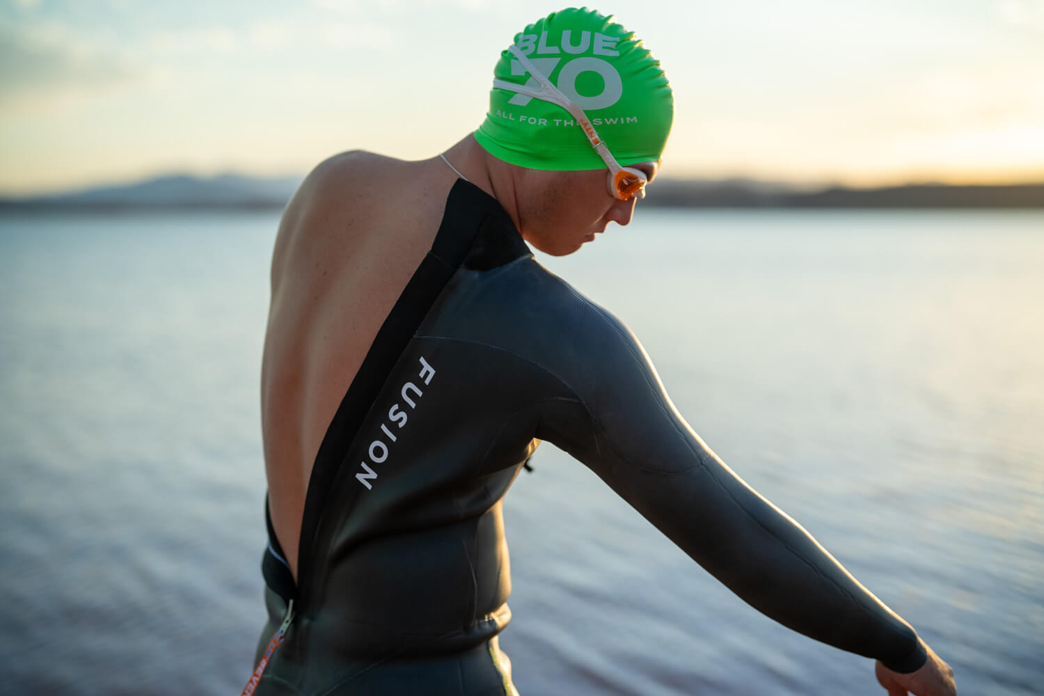 swimmer putting on Fusion Wetsuit