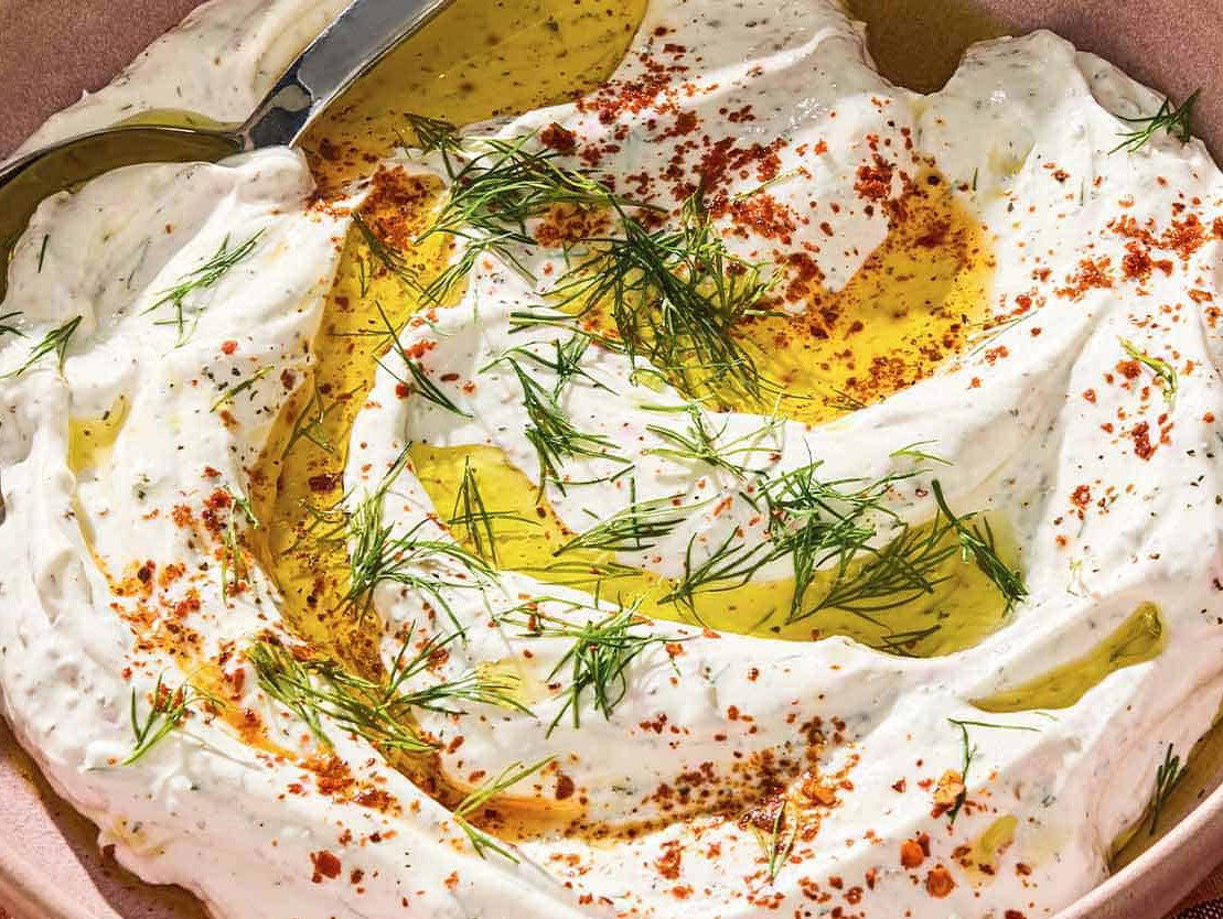 Turkish yogurt dip in a serving bowl with a spoon.