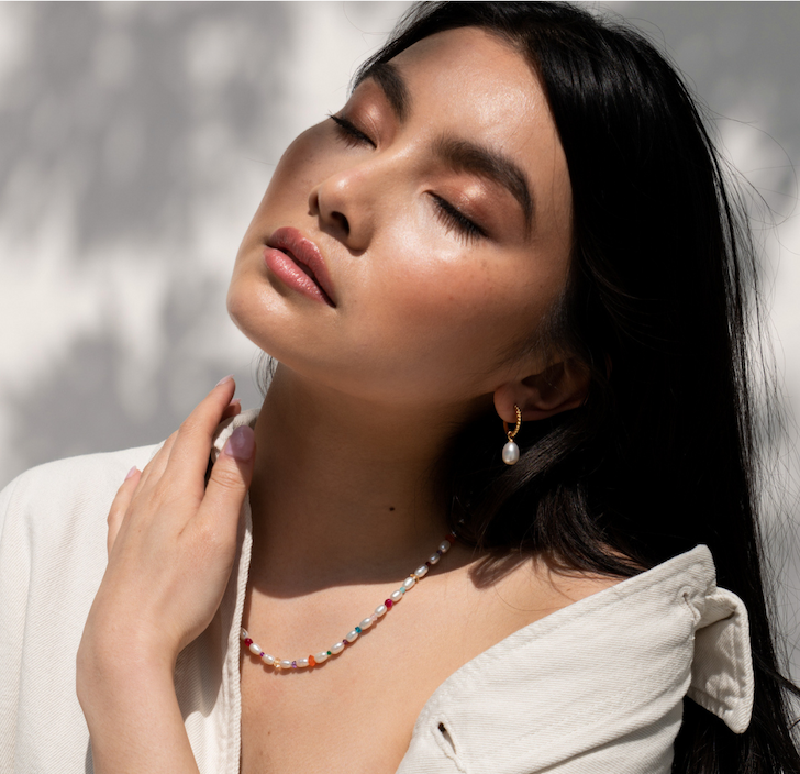 Model wears Carnival Necklace and Timeless Oval Pearl Hoops