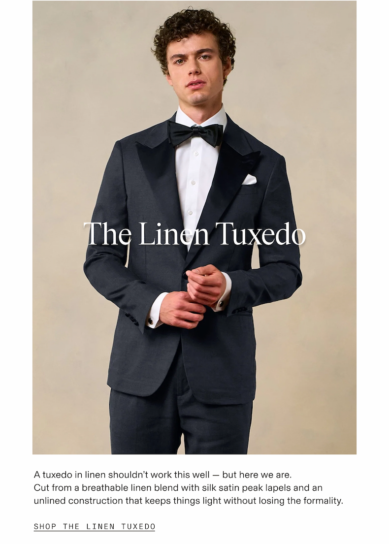 Man wearing a navy linen tuxedo with silk satin peak lapels, white dress shirt, dark green bow tie, and white pocket square, adjusting his cufflinks against a beige background. The Linen Tuxedo. A tuxedo in linen shouldn't work this well — but here we are. Cut from a breathable linen blend with silk satin peak lapels and an unlined construction that keeps things light without losing the formality. SHOP THE LINEN TUXEDO