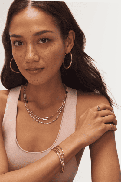 Woman wearing variety of yellow gold fine jewelry.