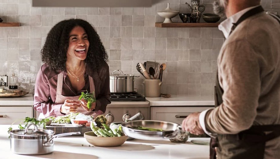 Image features a happy home cook laughing across the kitchen counter.