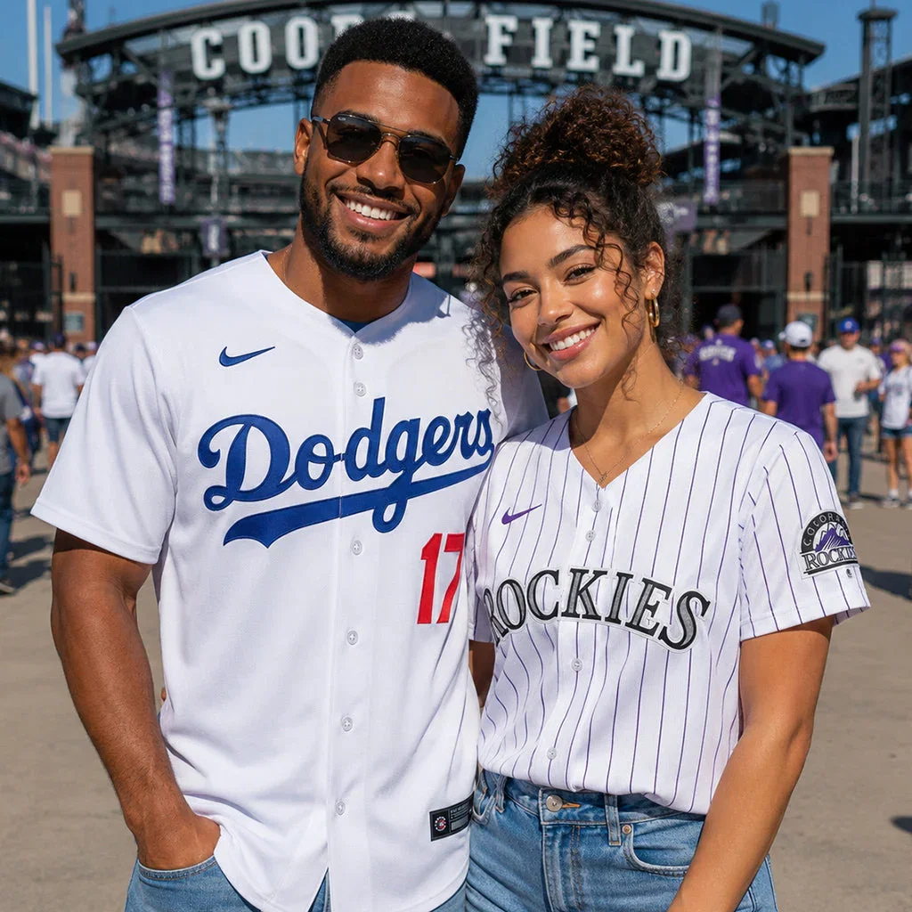 Two people wearing MLB jerseys at Coors Field stadium during a daytime game, smiling at the camera.