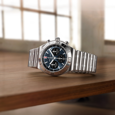 Breitling Chronomat watch with blue dial on its side on table