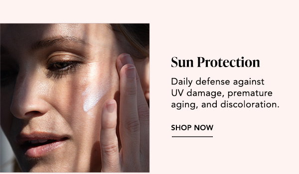 Portrait: Close-up of a woman applying SPF to her face in sunlight