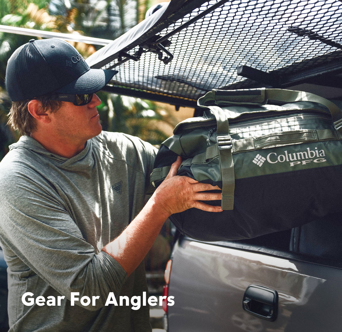 A man loading a green duffel in to the back of a grey pickup with text: Gear For Anglers