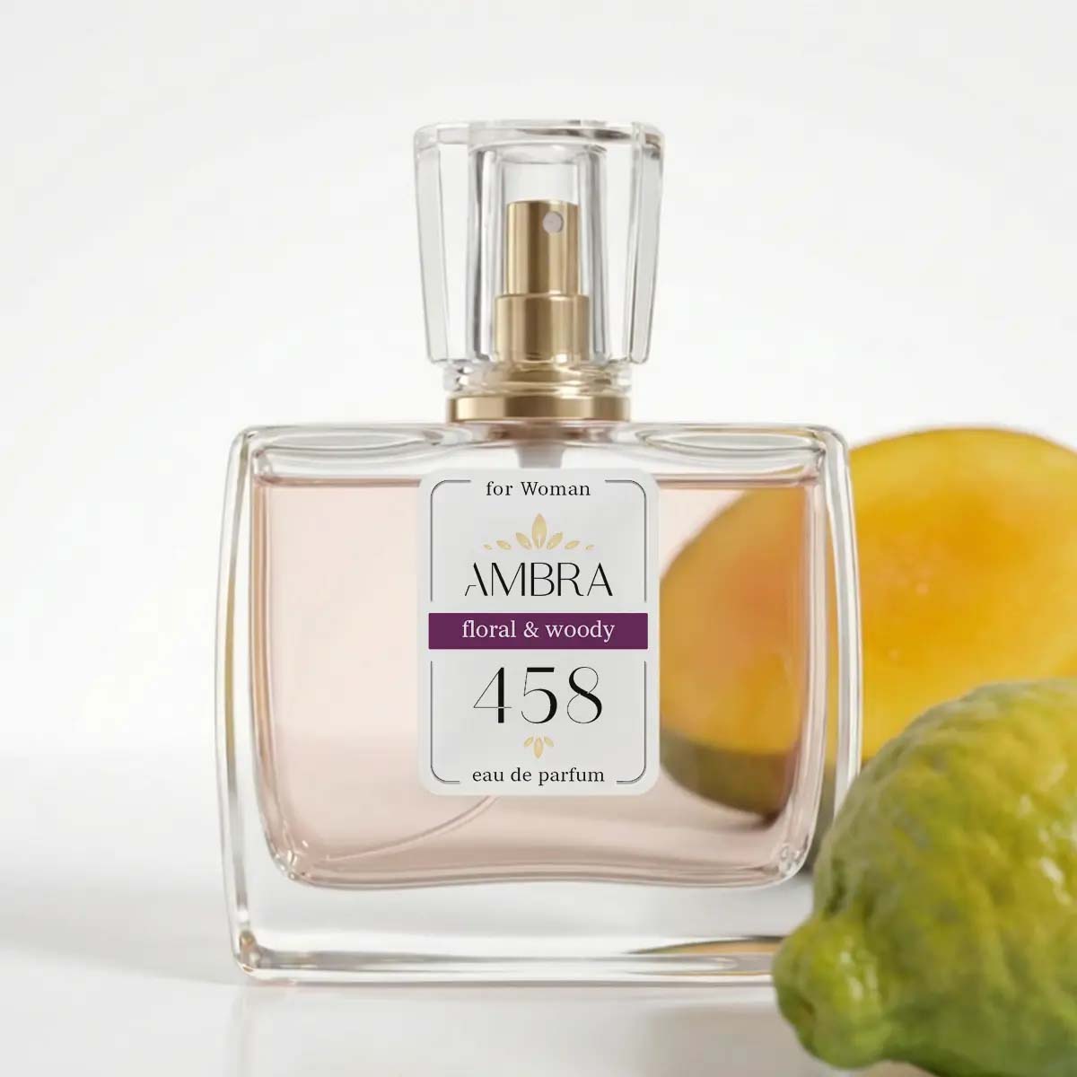 Glass perfume bottle labelled "AMBRA 458" floral & woody eau de parfum for women, with blurred citrus fruits in the background
