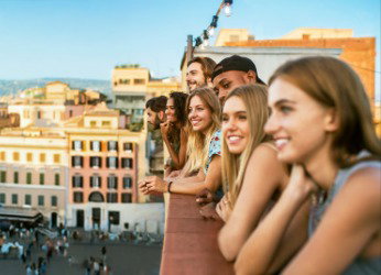 Un grupo de amigos se encuentra junto a un muro, contemplando Roma. Obtén más información sobre las visitas guiadas para grupos.