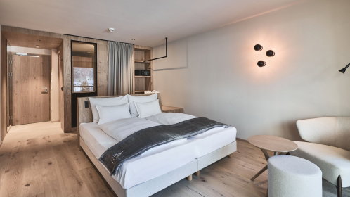 Hotel Doppelzimmer mit Doppelbett und gemütliche Sessel und Tisch