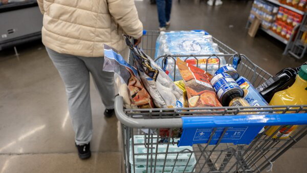 A customer shops with a filled grocery cart at Walmart in Little Rock, Ark.