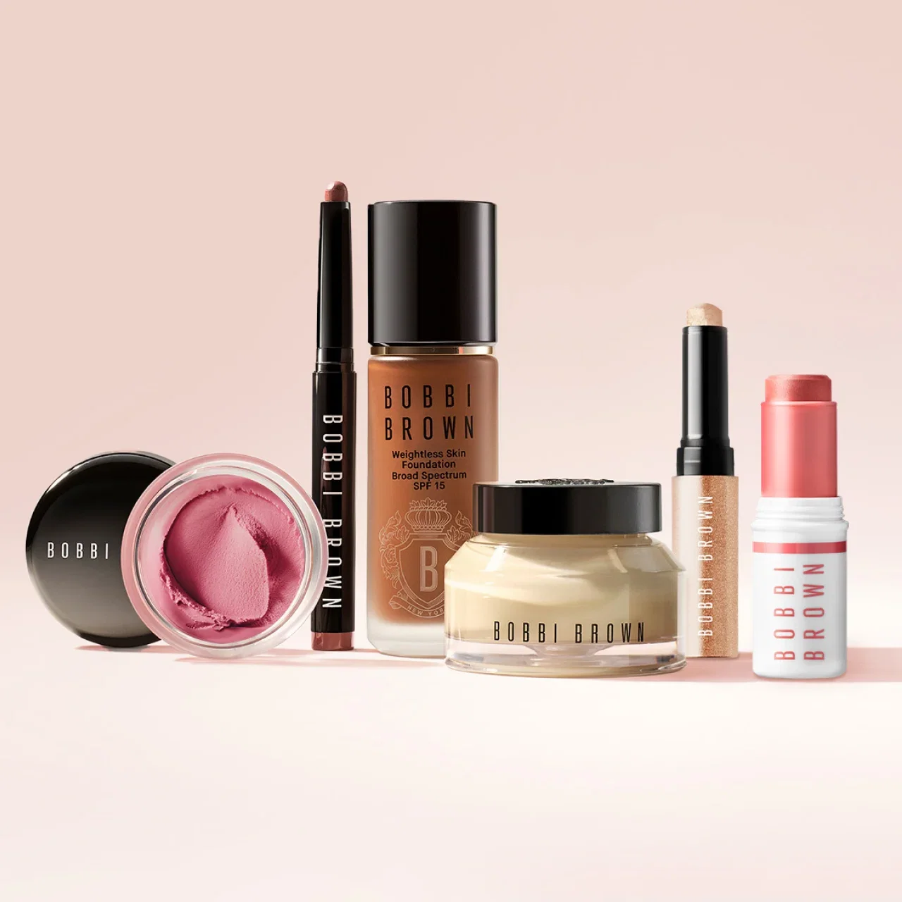 Bobbi Brown bestsellers lined up on a gradient cream background.