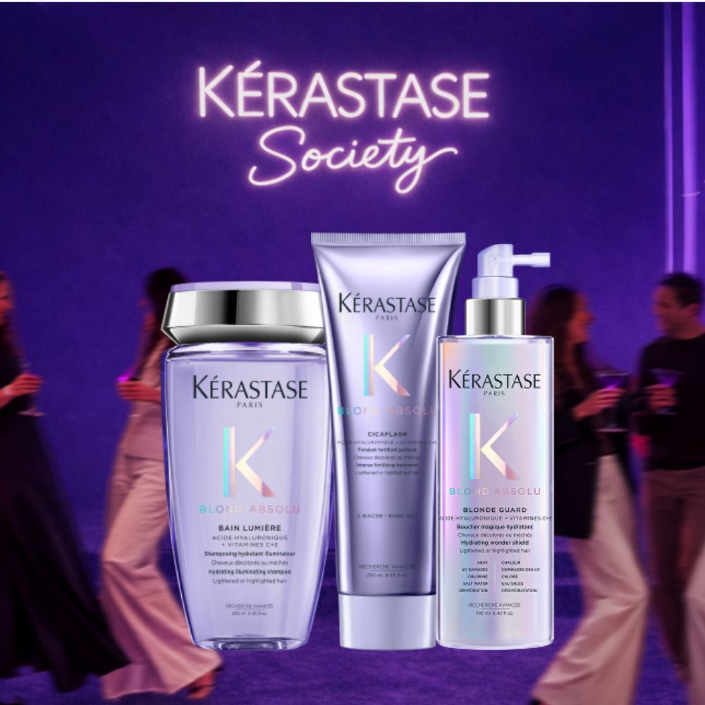 Tre prodotti Kérastase Blond Absolu — shampoo, balsamo e spray — su sfondo viola con scritta Society al neon