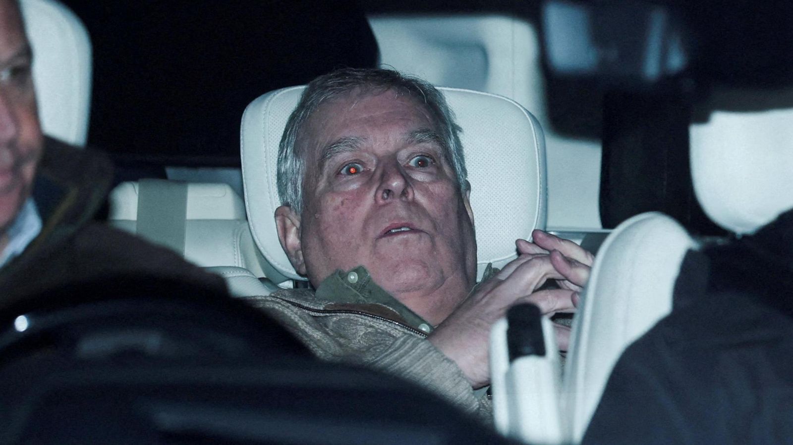 Andrew Mountbatten-Windsor is pictured slumped in the back seat of a car.